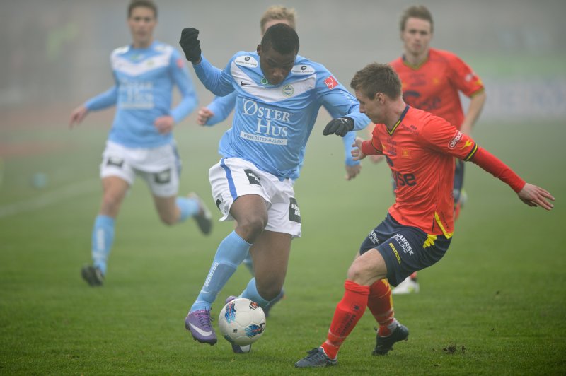 Sandnes Ulfs Gilles Ondo scoret kampens første mål. Her i duell med Vikings Trond Erik Bertelsen. Foto: Kent Skibstad / Scanpix